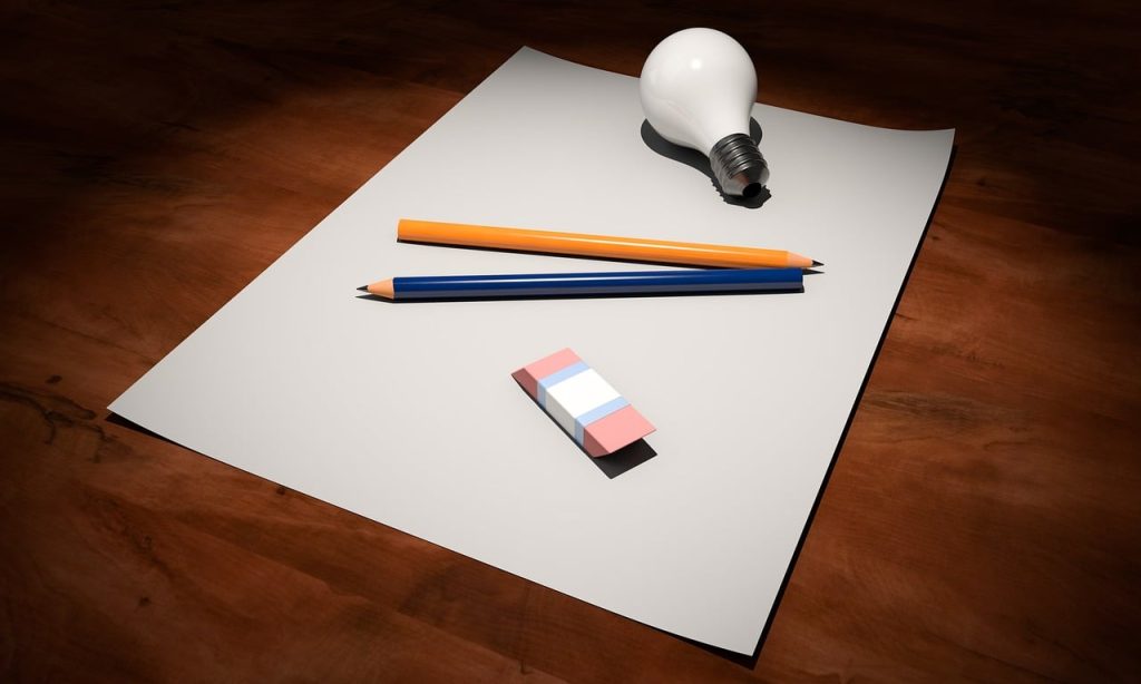 Lightbulb, pencil, and paper symbolizing best practices for logic models and program planning